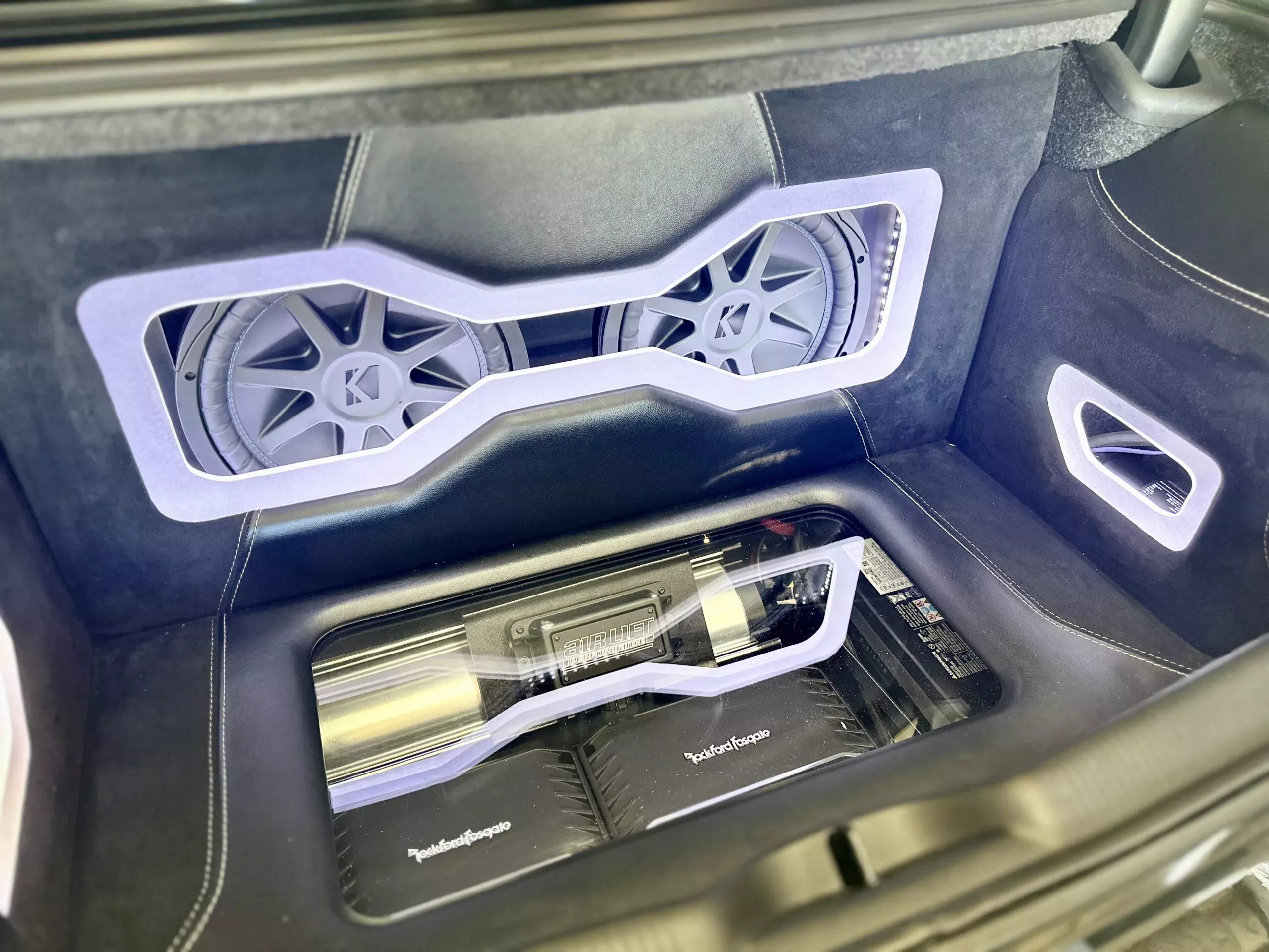 Custom car audio system with acrylic and leather inside the trunk of a car